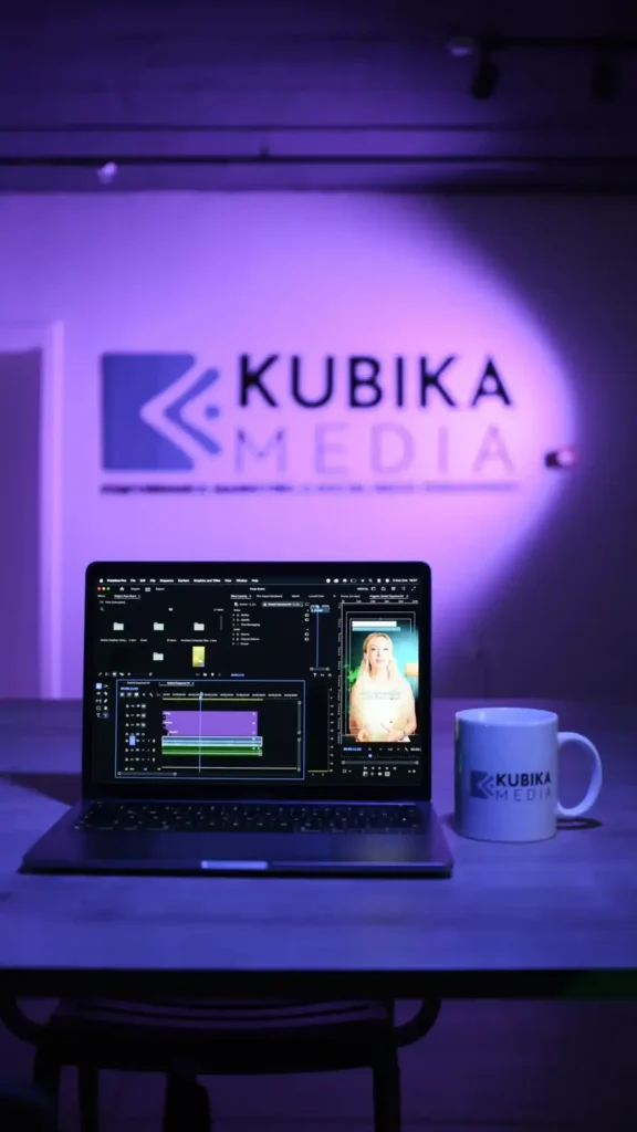 Kubika Media ofisinde mor ışıklı logo duvarı önünde kurgu yapılan dizüstü bilgisayar
